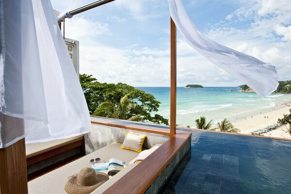 Swimming pool by the sea and palm trees