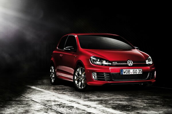 Red volkswagen drives out of the darkness