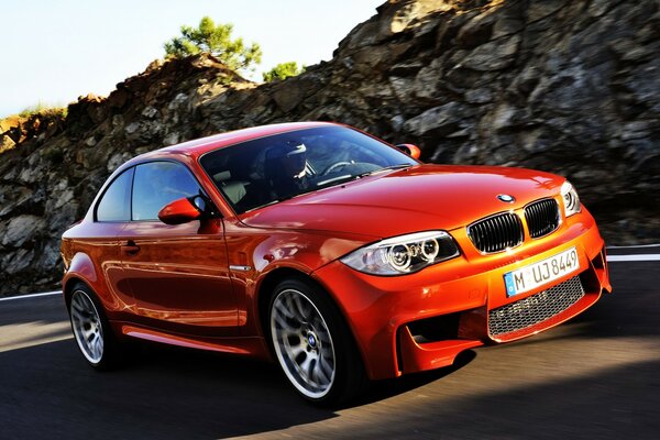 BMW coupé na pista com uma rocha