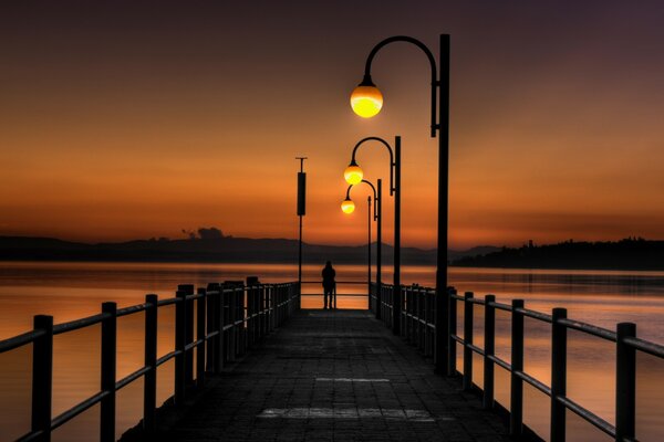 Pier bei Sonnenuntergang mit ungewöhnlichen Laternen