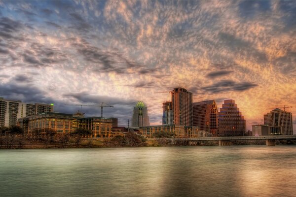 Tall houses by the water on the background of sunset