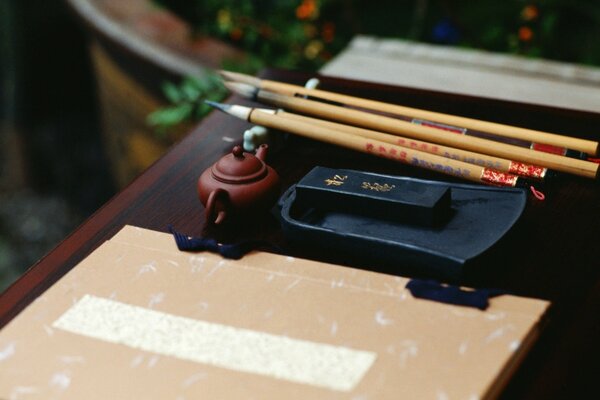 Kettle, notebook, pencils on the table