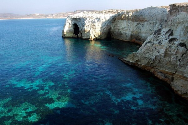 Das griechische blaue Wasser wäscht die Felsen