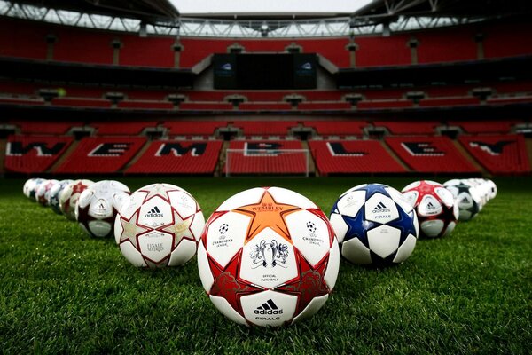 Soccer balls are lying on a green sports field