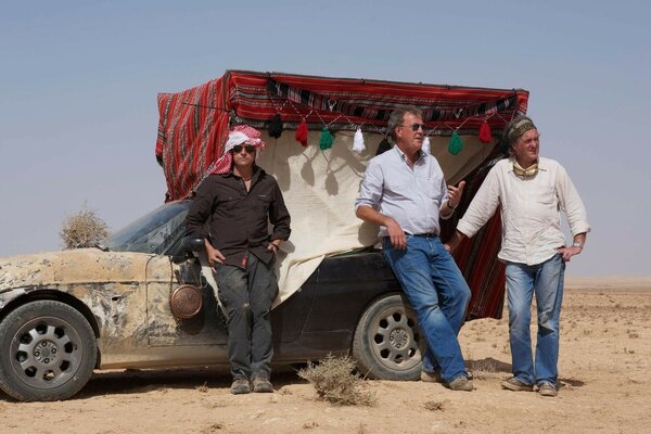 Three adult men near the car