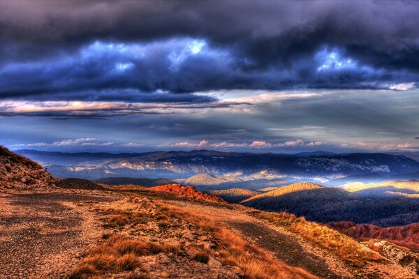 Sunset in a gloomy sky over the hills