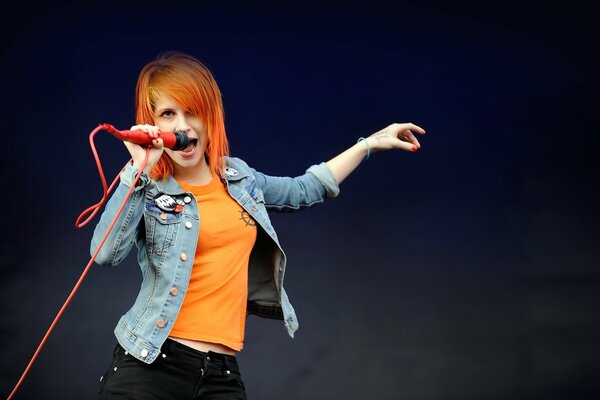 Singer with red hair on a black background