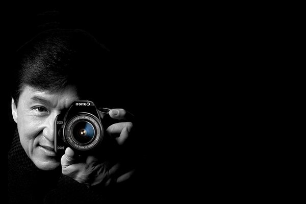 Actor with a camera on a black background