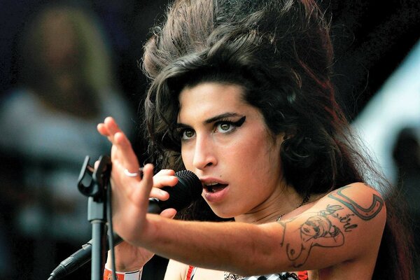 Amy Winehouse with a microphone on stage