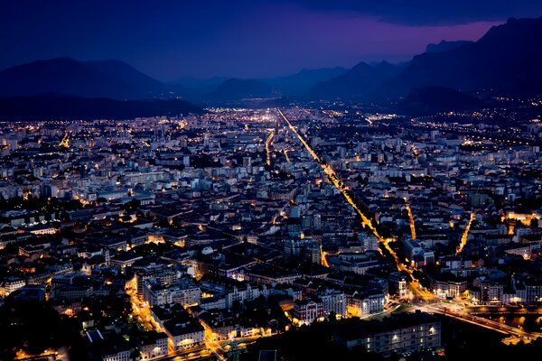 Nachtstadt im Hintergrund der Berge