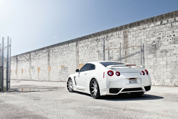 Weißer Nissan auf Backsteinmauer Hintergrund