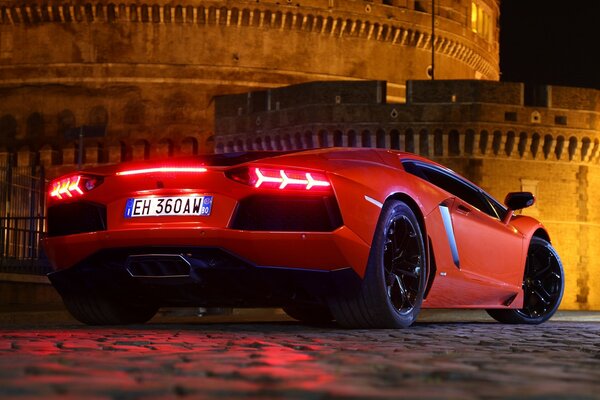 Lamborghini rojo en la calle por la noche