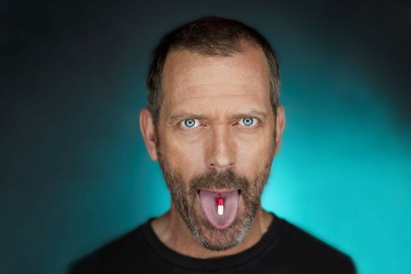 Actor with a pill in his mouth, dark background