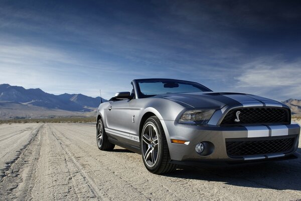 A gray car is parked in the desert