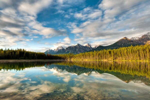 A clear mountain lake in which clouds are reflected