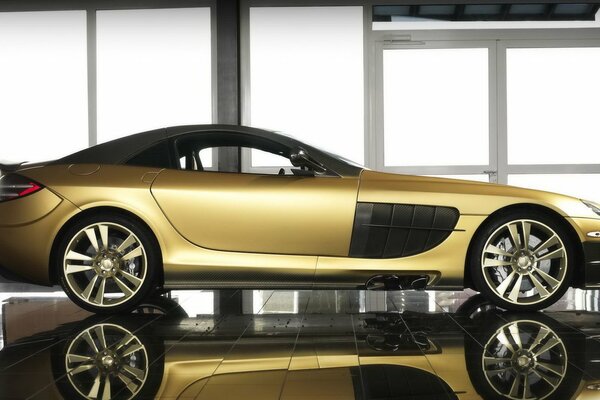 Золотой mansory mercedes-benz на фоне панорамных окон. Роскошный автомобиль золотого цвета