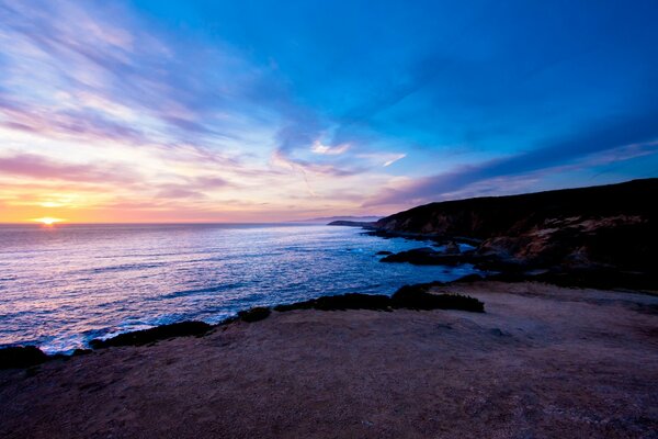 O céu azul da noite e o sol se põe nas profundezas do oceano