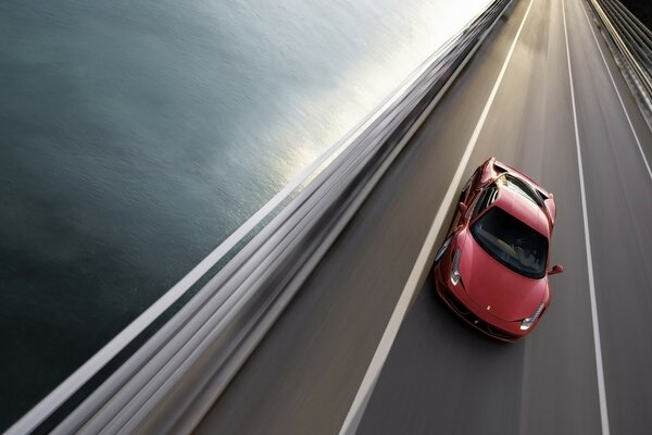 Red Ferrari rushes along the highway