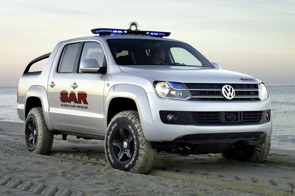 Volkswagen gris en la playa de arena