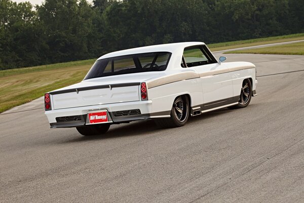 A white car rushes along the road