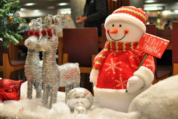 Schneemann im roten Pullover mit silbrigen Hirschen