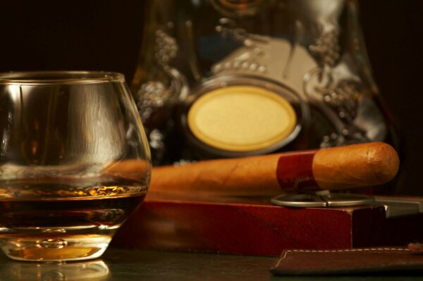 Whiskey in a glass next to a cigar