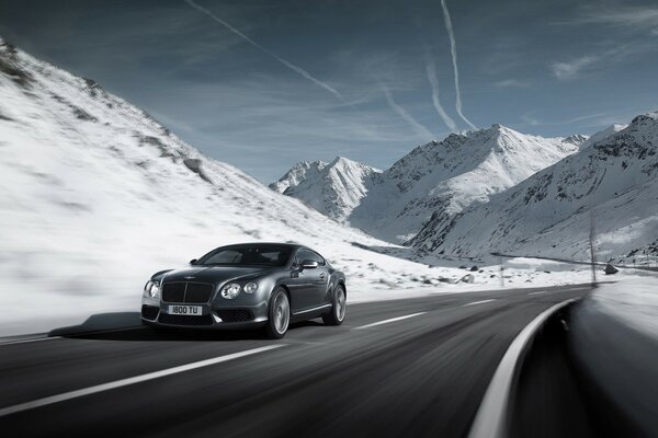 Bentley is driving on the road. In the snowy mountains