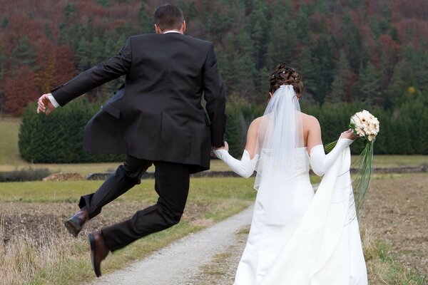 The newlyweds walk. The man jumped for joy