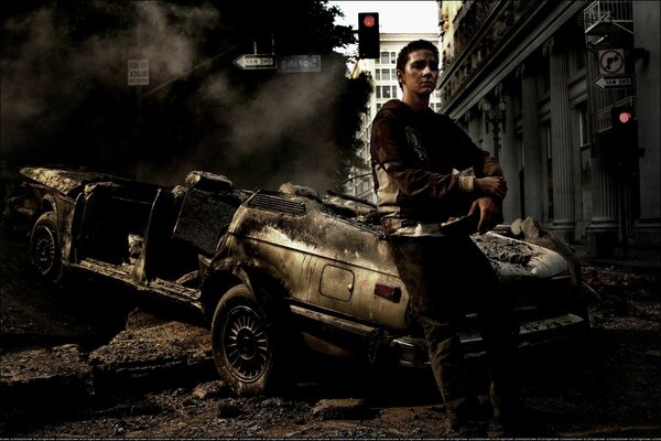 A girl standing near a broken car