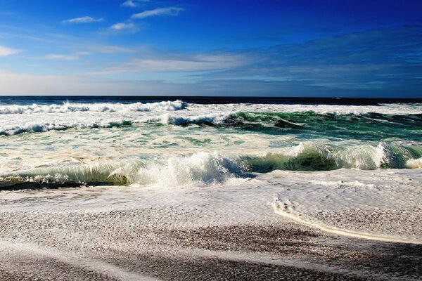 Olas del mar en la costa de arena