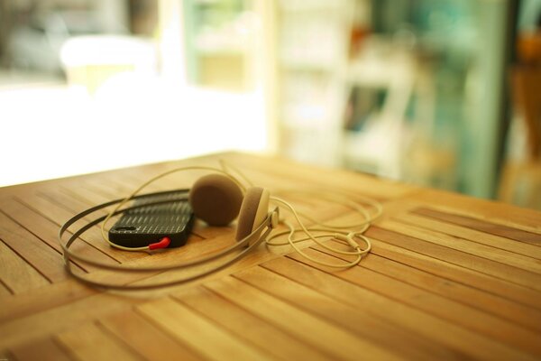 The headphones are lying on a wooden table