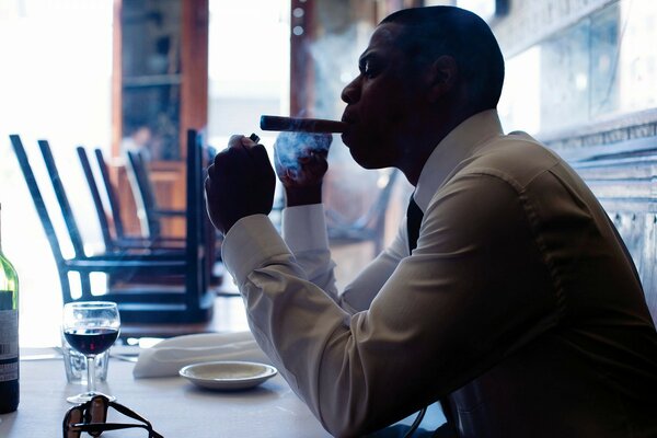 Smoking businessman with a glass of wine