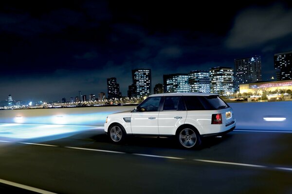 Джип land rover мчится по дороге в городе