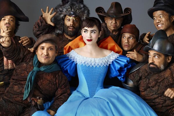 Snow White in a blue dress and the seven dwarfs