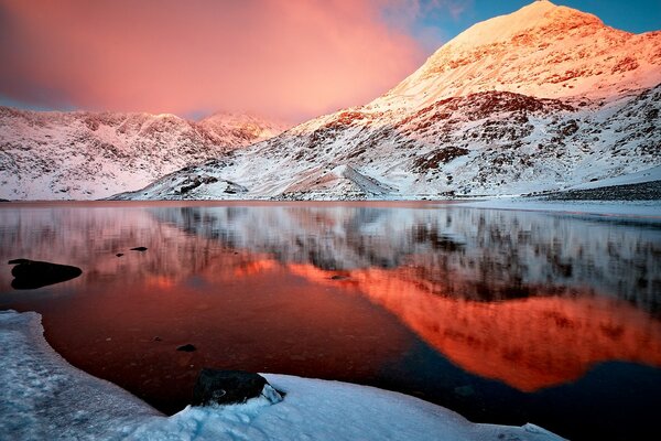 Herrliche schneebedeckte Berge und ihre Reflexion im Wasser