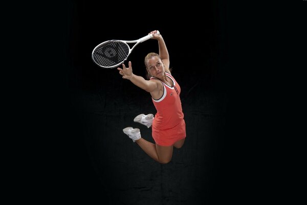 A tennis player swings the ball in a jump