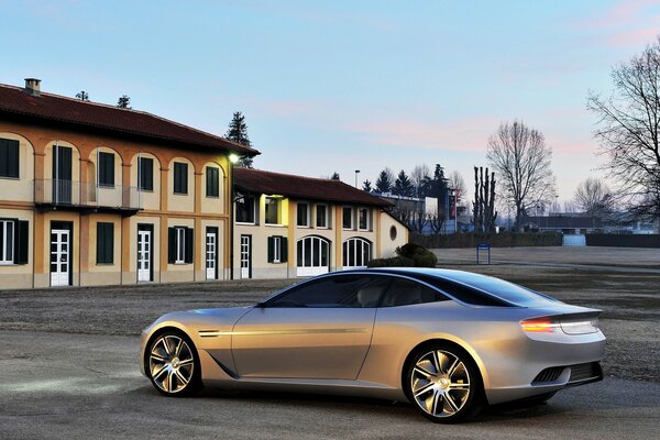 A silver car rushes through the city