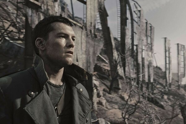 A handsome man on the background of destroyed houses