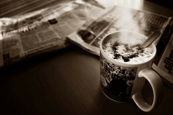 Tazza di caffè schiuma cuore giornale scrivania foto seppia