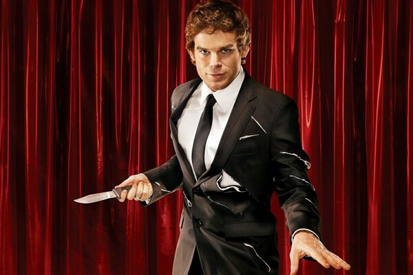 A man in a suit with a knife on the background of a curtain