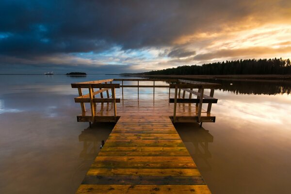 A bridge on the river against the sunset sky