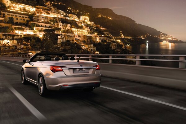 A convertible car on the background of a night city