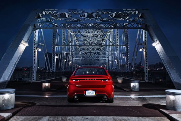 Coche rojo en el puente nocturno