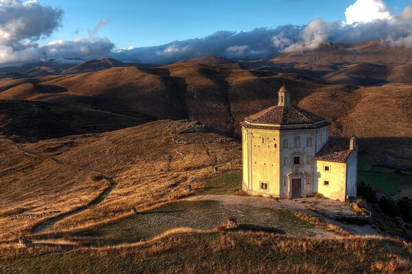 Paisagem de montanha italiana com uma casa antiga