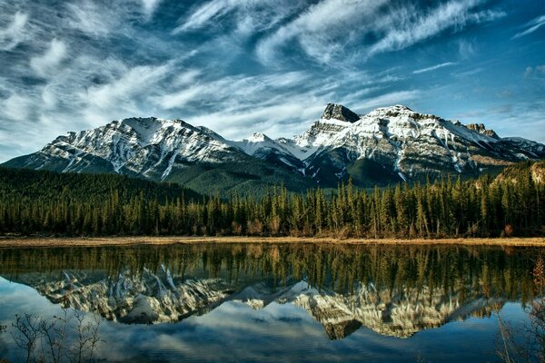 Lago de Taiga y colinas cubiertas de nieve