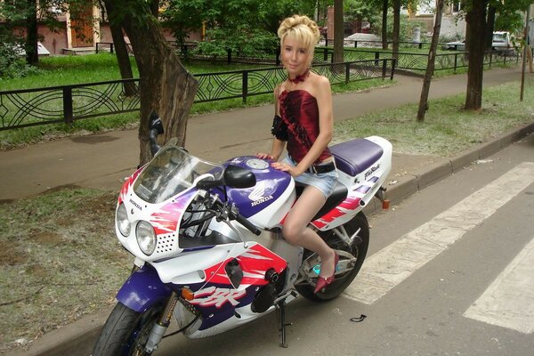 Женщина в миниюбке на мотоцикле на дороге