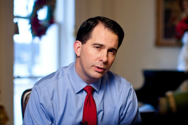 A middle-aged man in a red tie and a blue shirt