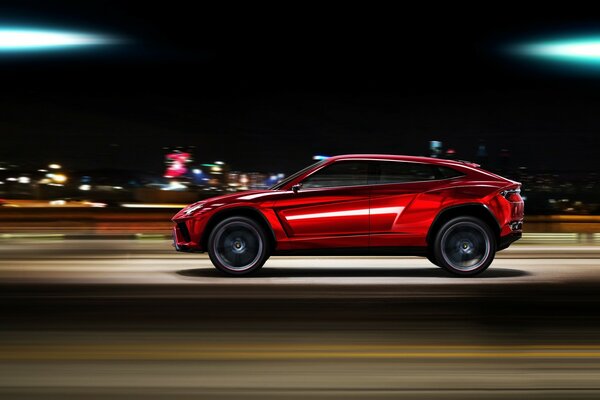 Un coche rojo corre por la ciudad de la noche