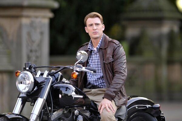 The actor is sitting on a motorcycle