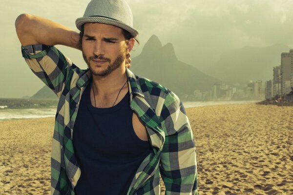 Hombre en la playa con camisa a cuadros